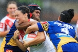 A woman is tackled during a rugby league match 