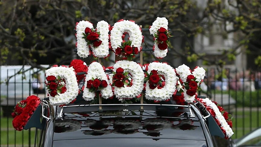 Flowers on top of Keith Palmer's hearse spell 'No 1 Daddy'