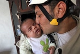 Syrian baby boy with man who rescued him from rubble