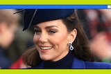 Kate is seen wearing a blue fascinator and complementary blue coat, turtle neck and diamond/sapphire earrings as she smiles.