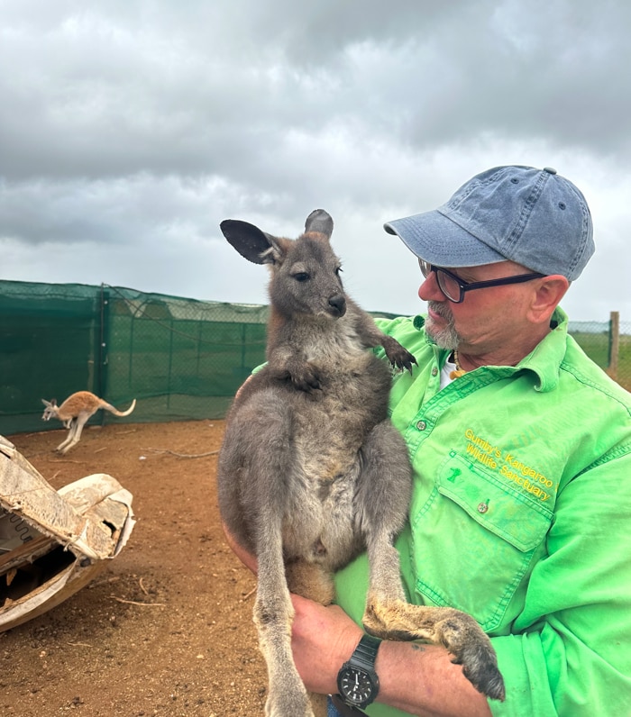 A man holds a kangaroo 