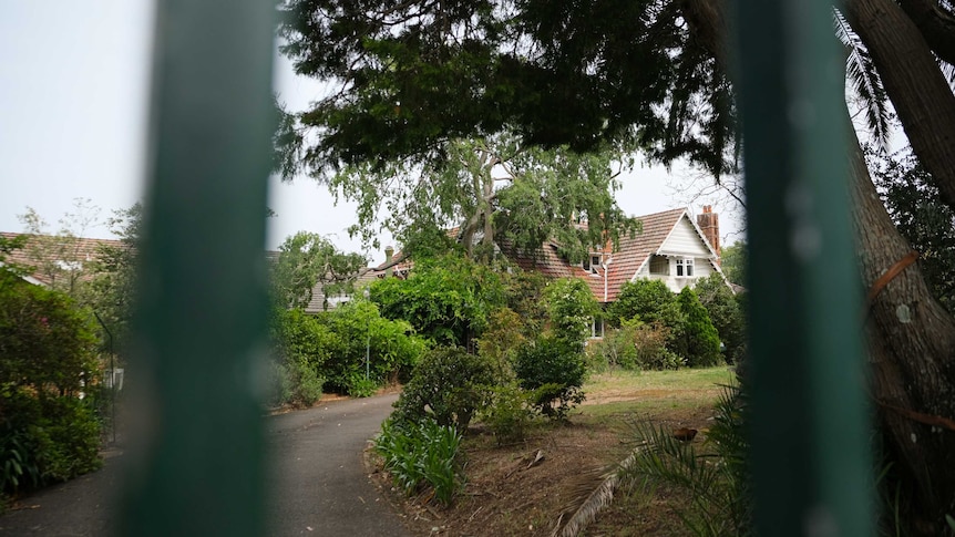 A photo of Beecroft House through a fence.