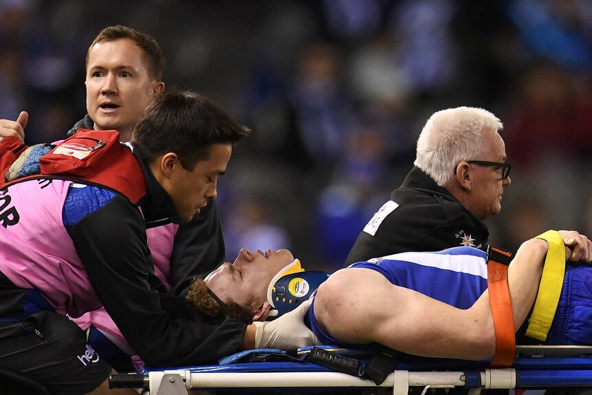 Ben Brown of the Kangaroos (3L) is treated for concussion against Collingwood on August 5, 2017.