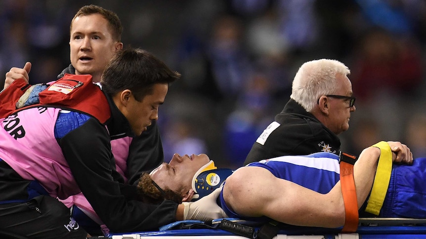 The Kangaroos' Ben Brown is taken off on a stretcher against Collingwood