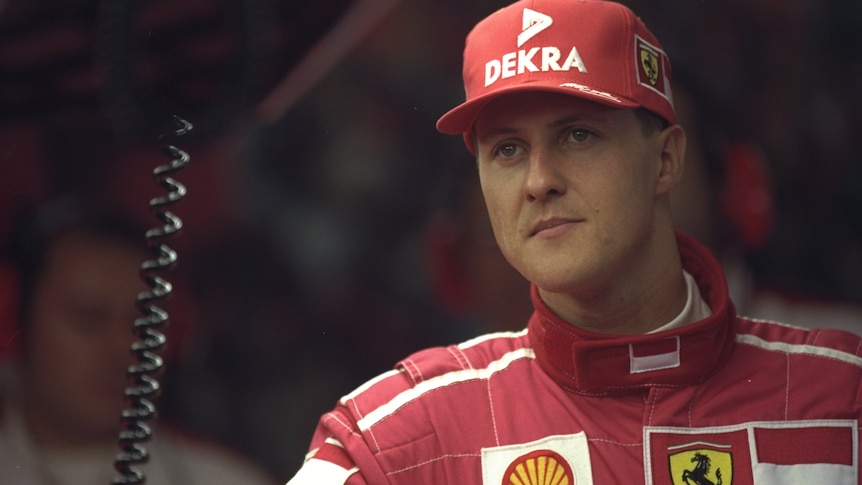 Michael Schumacher looks to one side in Ferrari kit