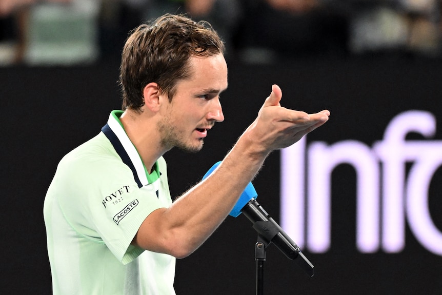 Daniil Medvedev gestures to crowd during post-match interview.