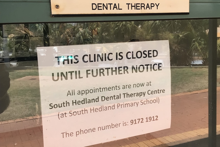 A sign on a glass door reading "this clinic is closed until further notice"