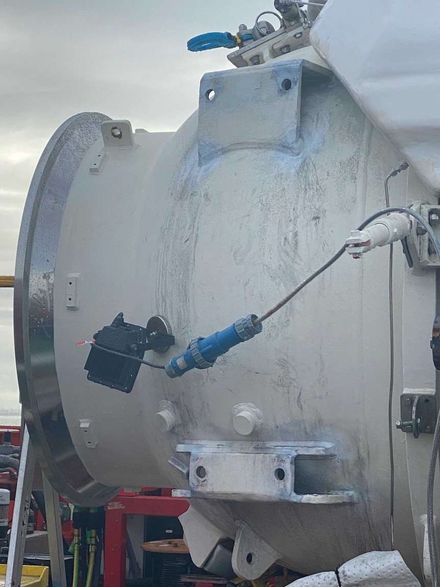 A submersible vessel sits on the deck of a boat