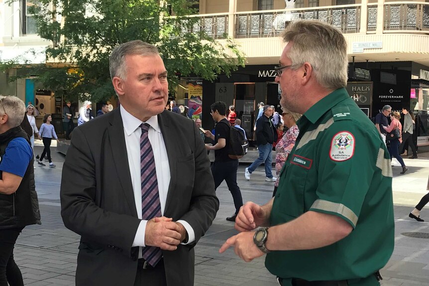 Health Minister Stephen Wade talking to an ambulance officer.