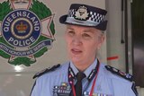 Queensland Police Service Commissioner Katarina Carroll wearing uniform next to service emblem on vehicle