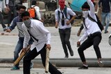 Kashmir school students in their uniforms, wearing backpacks, brandish sticks and throw rocks at Indian security forces.