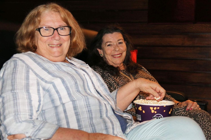 Cinema-goers Maria O'Neill and Colleen Hlavka enjoy popcorn during a movie in Brisbane.
