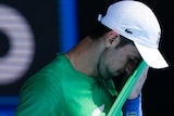 Novak Djokovic wipes sweat on his shirt