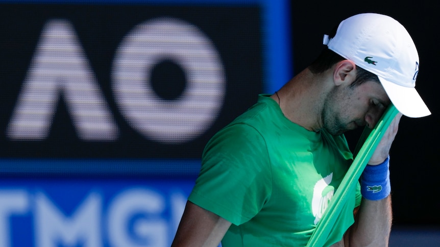 Novak Djokovic wipes the sweat off his face with the tail of his shirt during a match