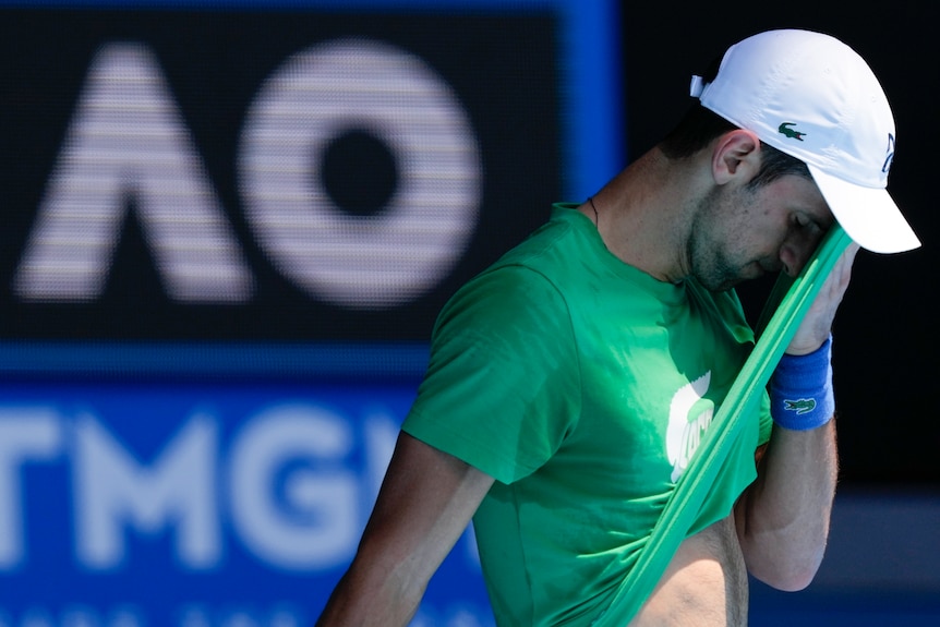 Novak Djokovic wipes sweat on his shirt