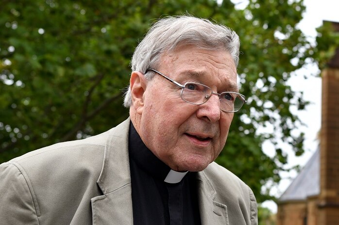 George Pell walks along a footpath outside St Mary's Cathedral in Sydney.