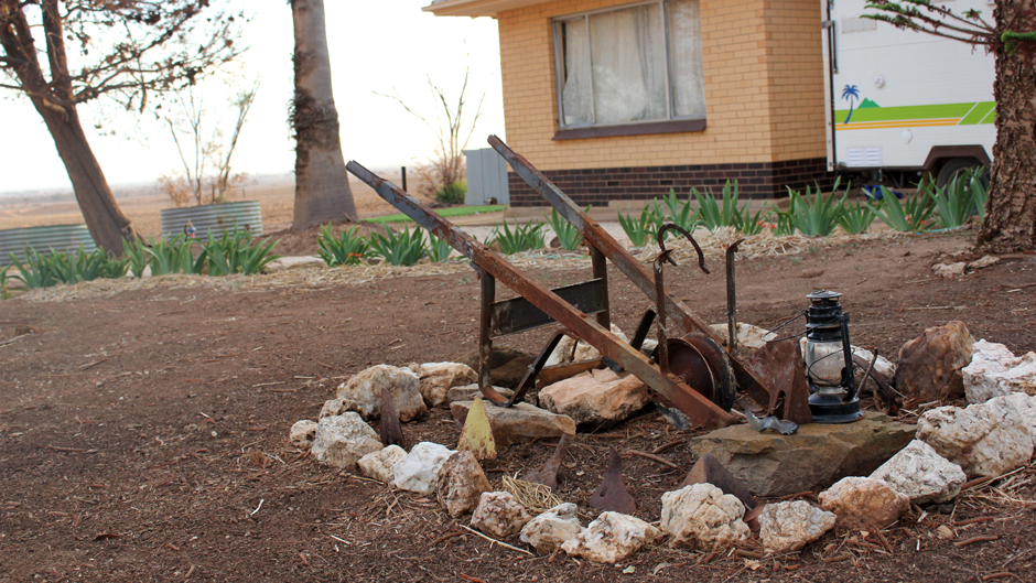A small display of rocks and the burnt remains of a wheelbarrow and other fire-damaged artefacts.