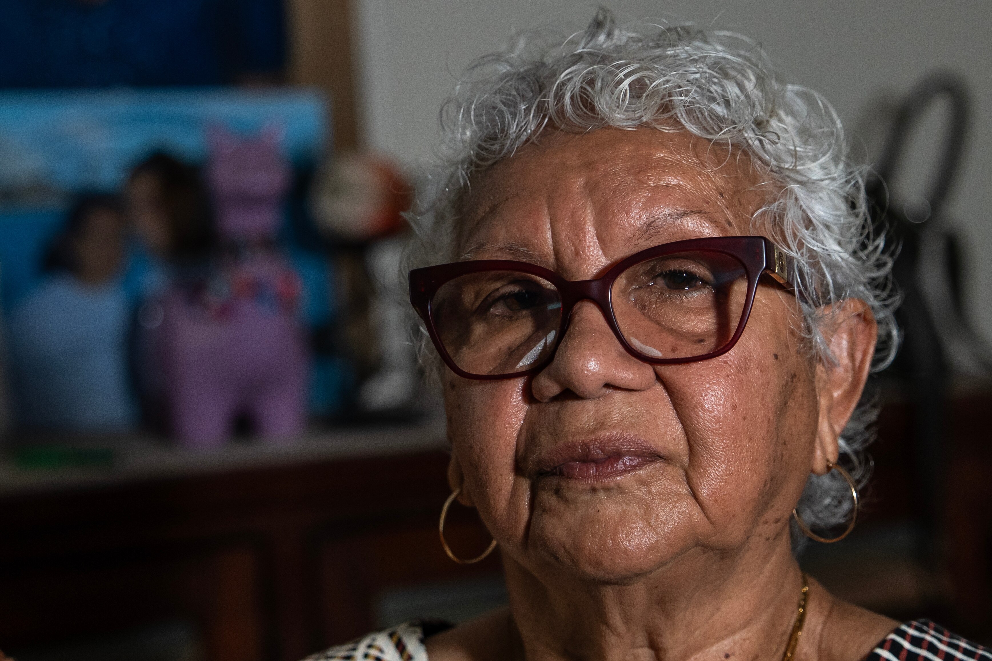 A close up of an elderly woman with glasses and white hair. 