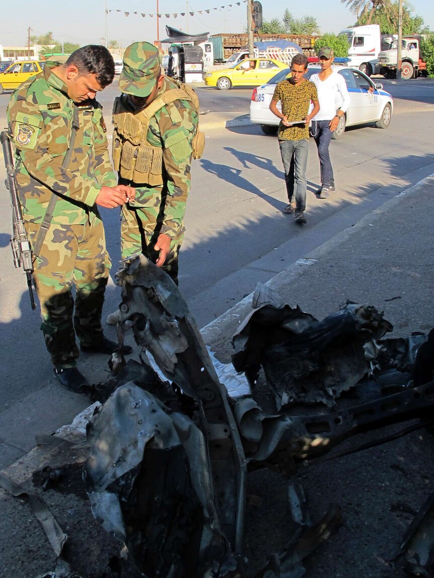 Police inspect the site of a car bomb attack in Baghdad's mainly Shi-ite Al-Amil district.