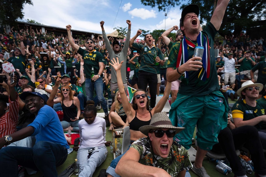 Fans in South Africa cheer while watching their team in the Rugby World Cup final.