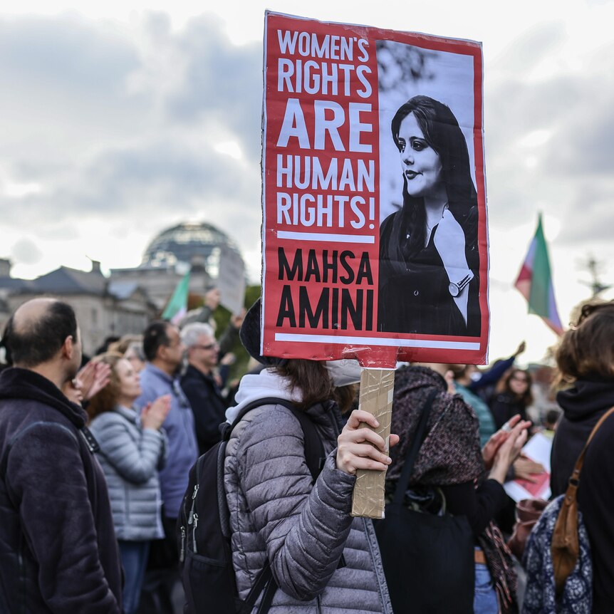Crowds of men and women holding a banner saying Women's Rights are Human Rights