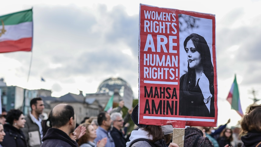 Crowds of men and women holding a banner saying Women's Rights are Human Rights