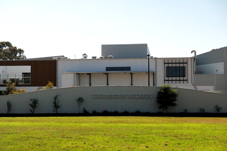 A a grey building with a sign in front reading Shepparton Villages