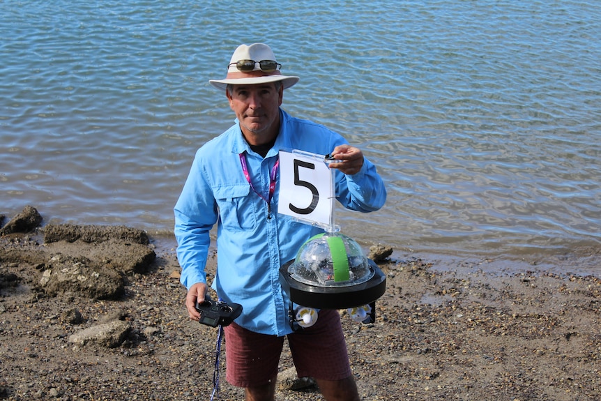 Andrew Wilson holding up radio controlled buoy.