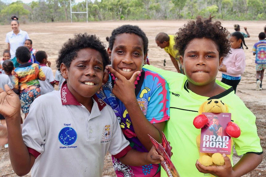 Three children from a remote Indigenous community posing for a photo