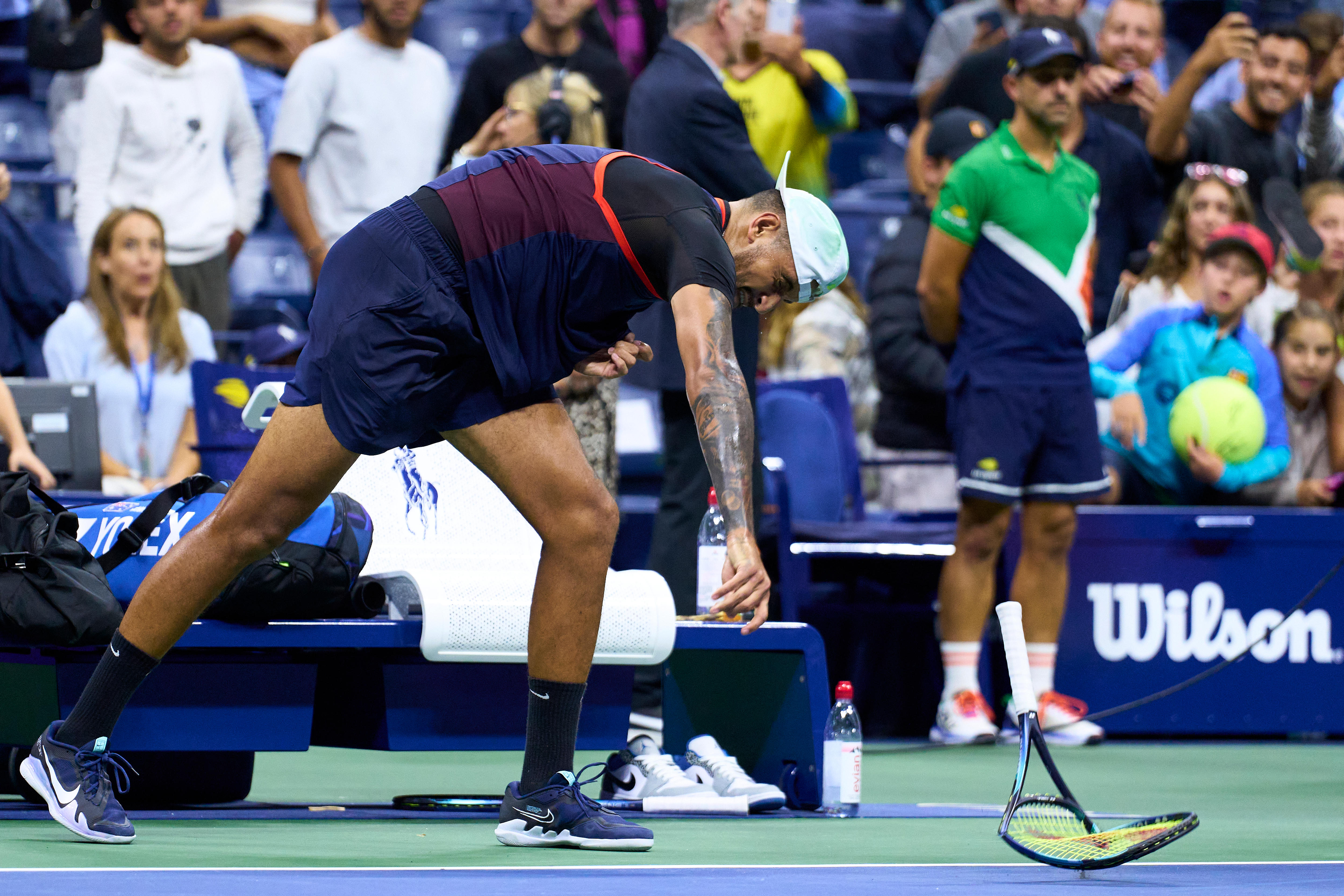 An Australian male tennis player smashes his racquet on the court at the US Open.