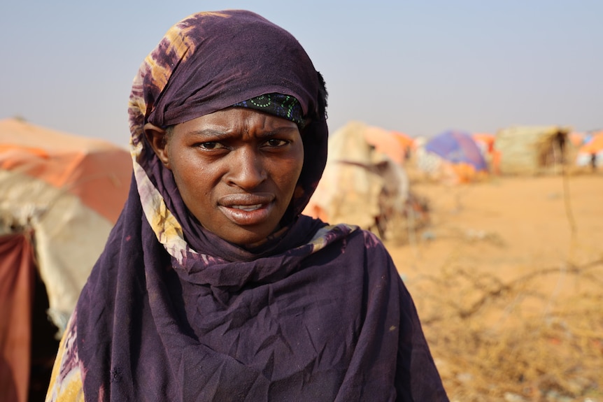 A woman in front of tents.