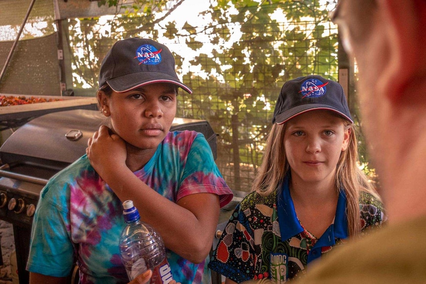 Two young students listen to a teacher