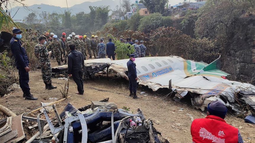 Rescuers stand by wreckage of a passenger plane that crashed in Pokhara, Nepal.