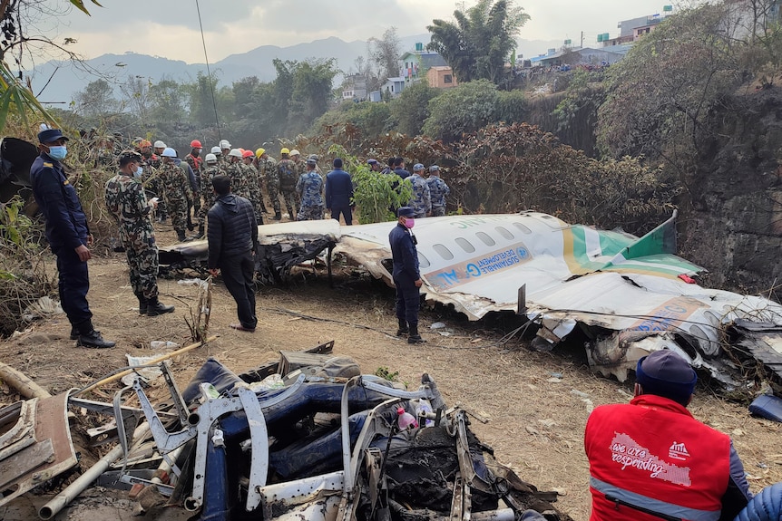 Rescuers stand by wreckage of a passenger plane that crashed in Pokhara, Nepal.