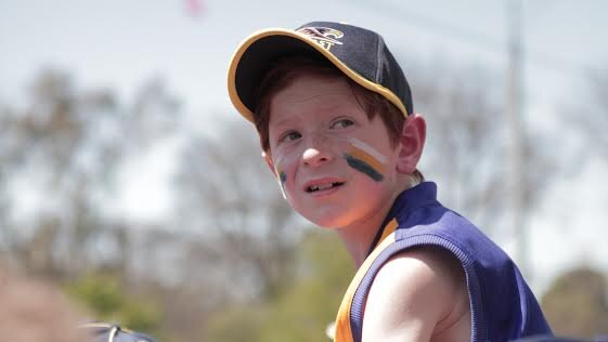 A young West Coast Eagles fan looks on at the AFL grand final parade.