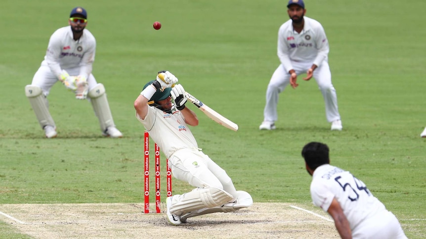 Australia's Marcus Harris hits the ball as Indian players watch on