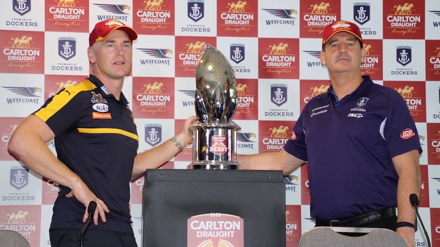 West Coast Eagles coach Adam Simpson (l) and Fremantle Dockers coach Ross Lyon stand beside the western derby trophy.