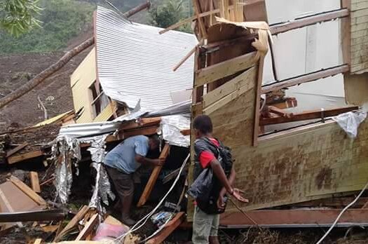 People inspect damaged houses.