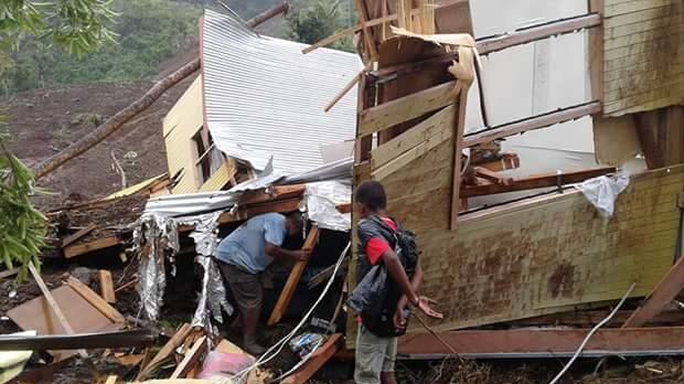 People inspect damaged houses.