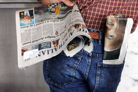 A man holding The Australian newspaper (Lisa Maree Williams: Getty Images)