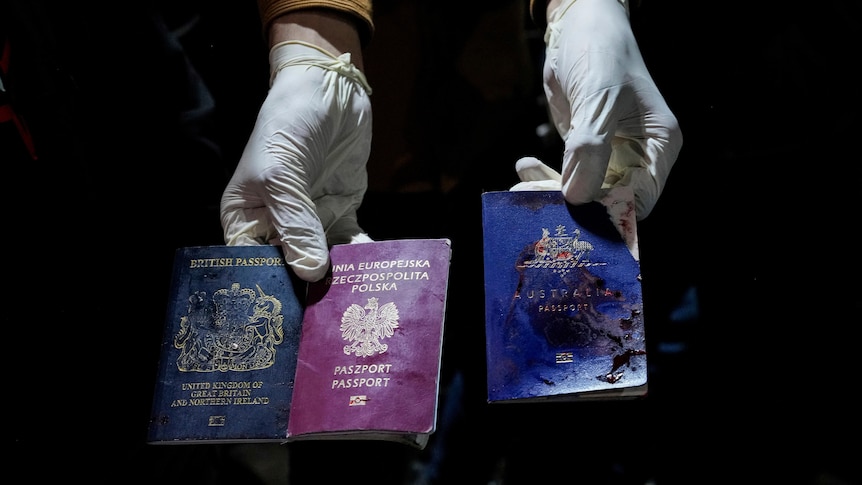A man holds bloodied British, Polish and Australian passports