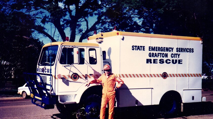 An old picture of an emergency services worker standing near a rescue vehicle