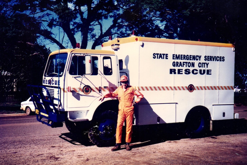 An old picture of an emergency services worker standing near a rescue vehicle