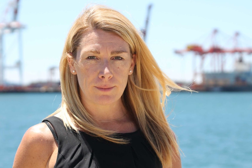 Kim Cullen standing in front of cranes at harbour