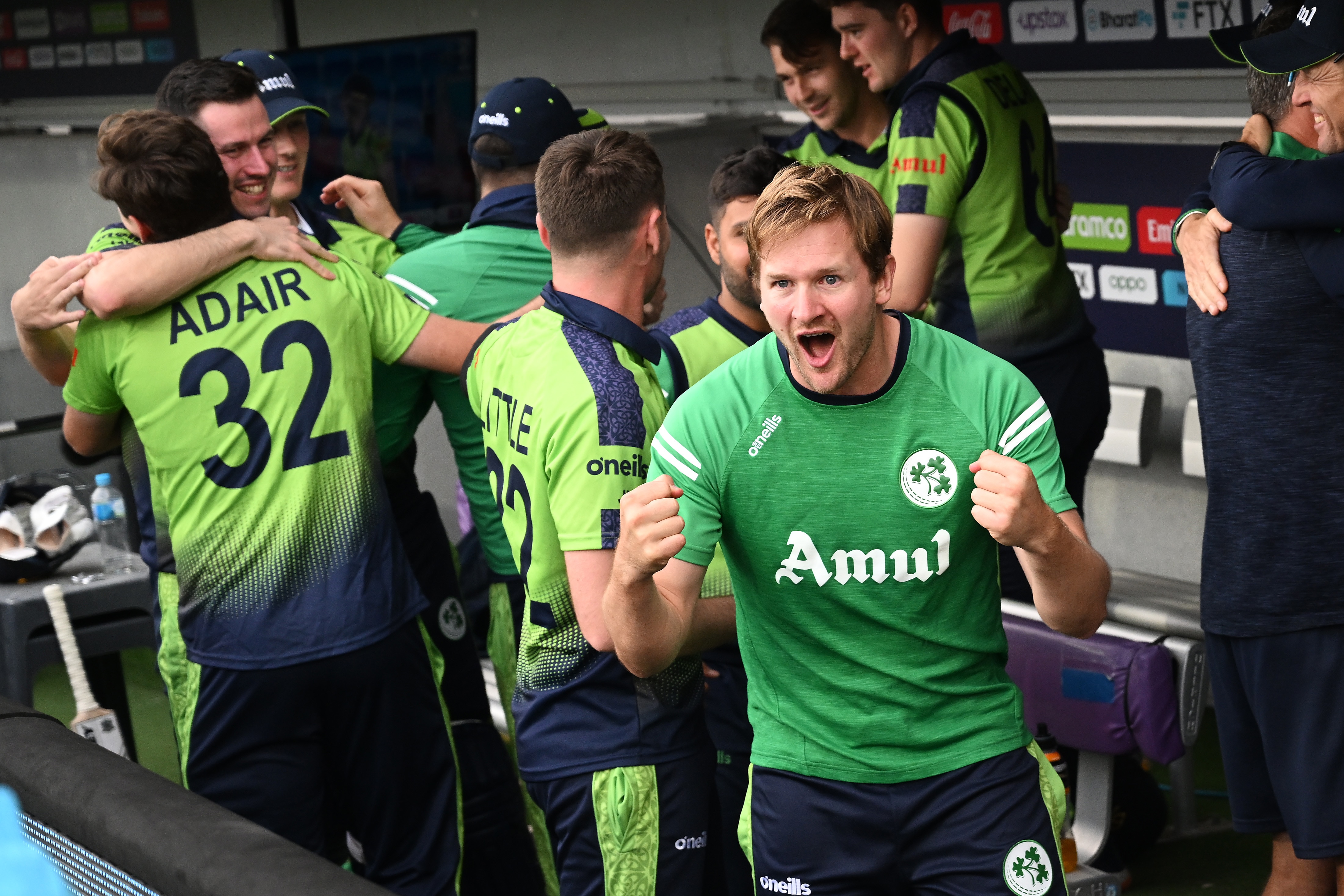 Barry McCarthy clenches his fist in celebration with Ireland teammates on the team bench