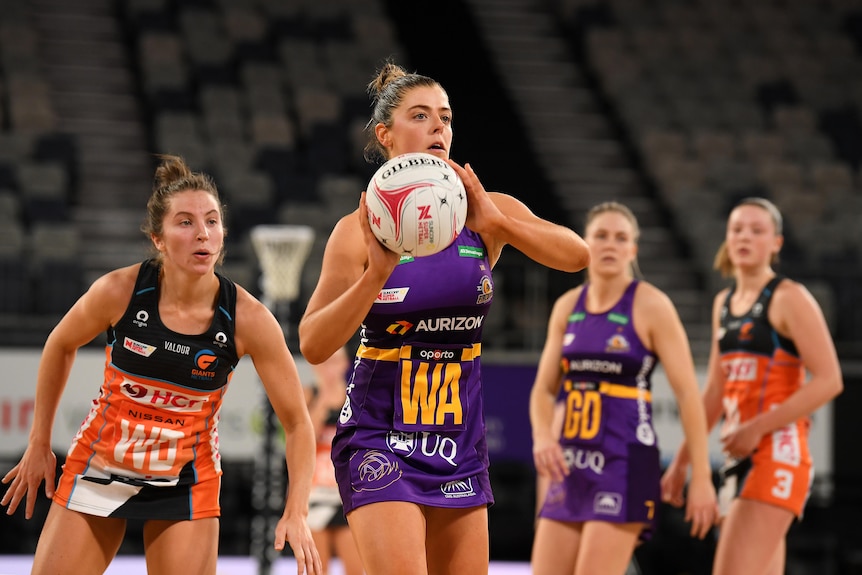 A Queensland Firebirds Super Netball player looks to pass the ball against the Giants.