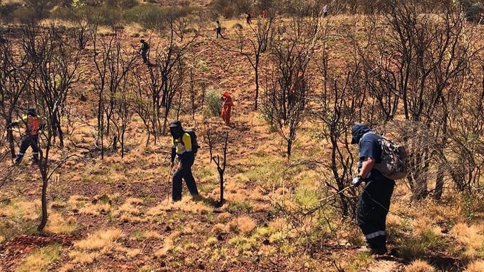 Emergency worker searching harsh terrain for the missing woman