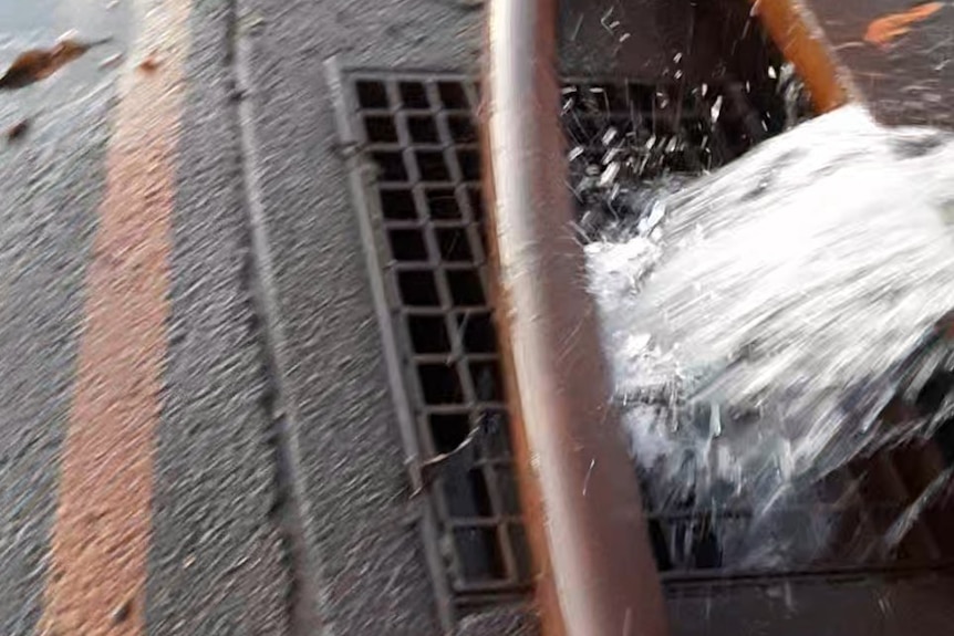 Photo of water being pumped into storm water drain.