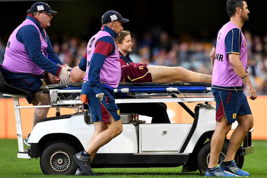 Harris Andrews of the Lions is taken off the field injured against GWS at the Gabba.