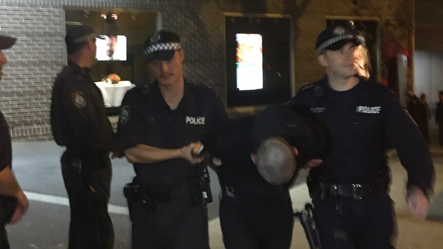A protester being taken away by police during the protest against Pauline Hanson in Ultimo.